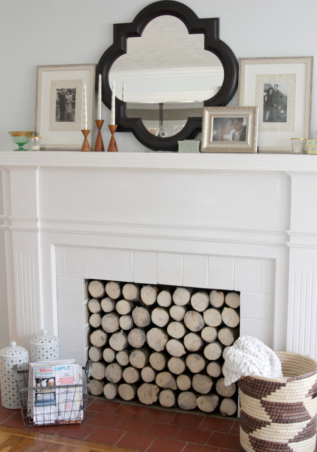 A DIY faux log stack easily hides an unsightly gas fireplace adding a rustic and modern charm.